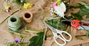 Florist's table with flowers, twine, and scissors. | Fancy Pancy